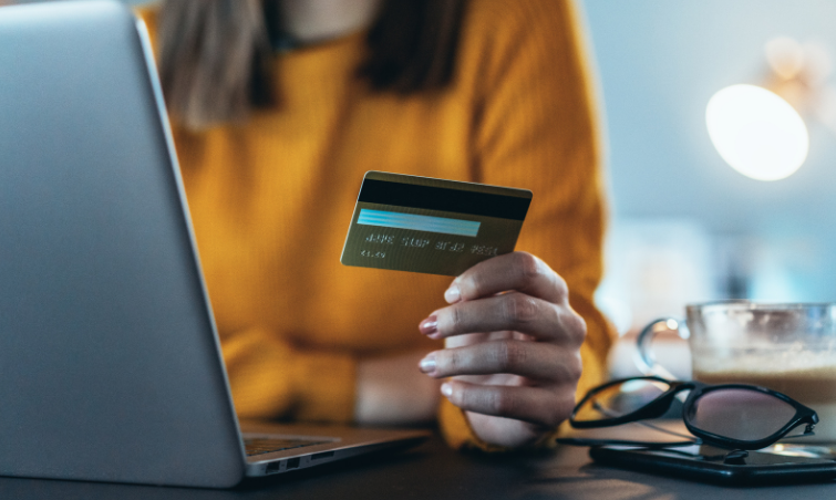 person holding credit card while working on computer