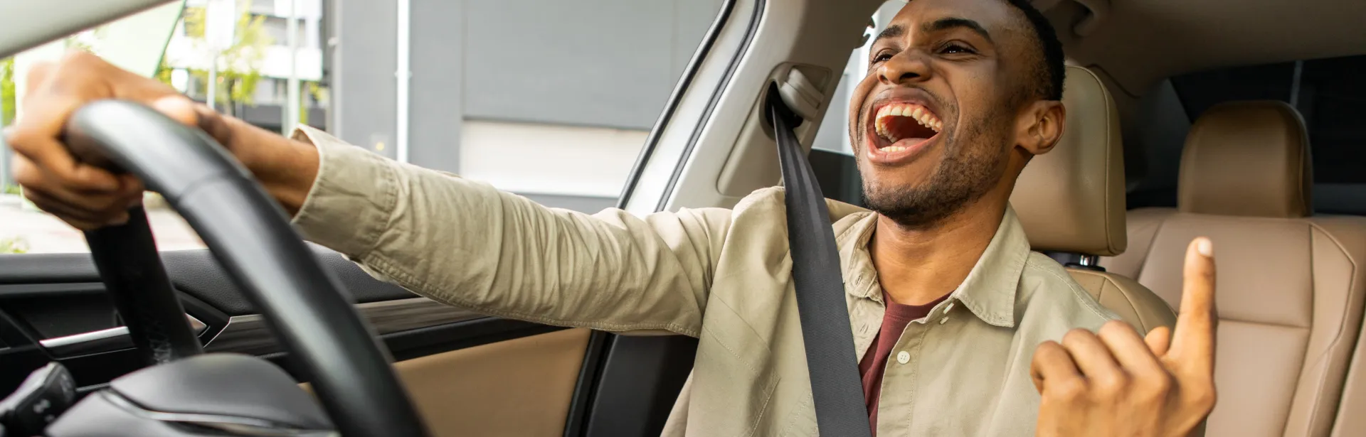 A man driving his car smiling.