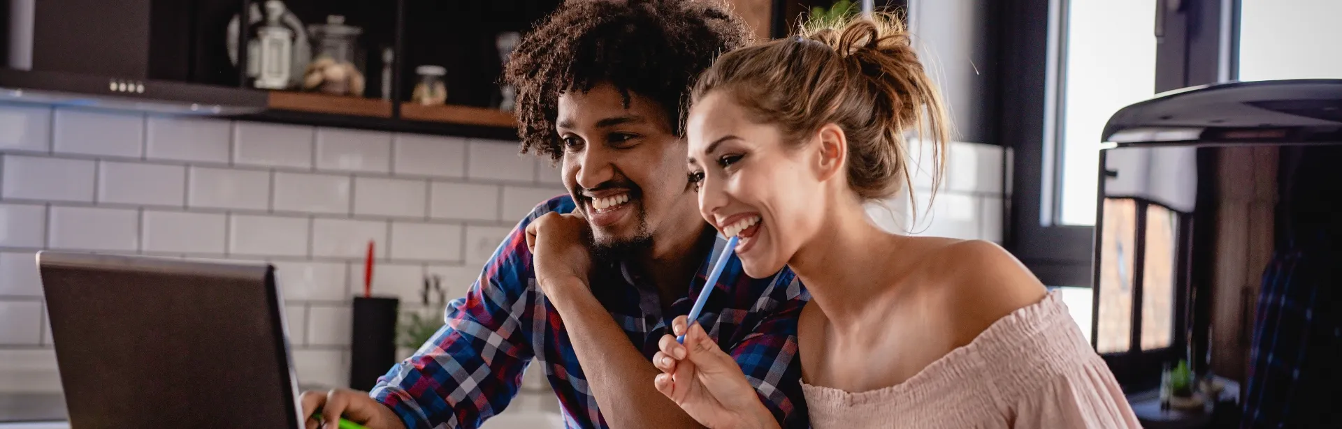 Two people looking at a computer screen and smiling.