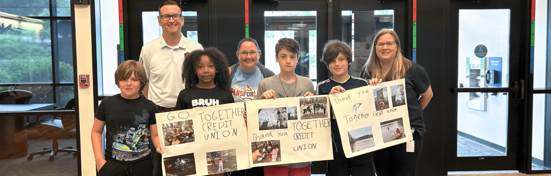 Four children holding up collages in support of Together Credit Union.