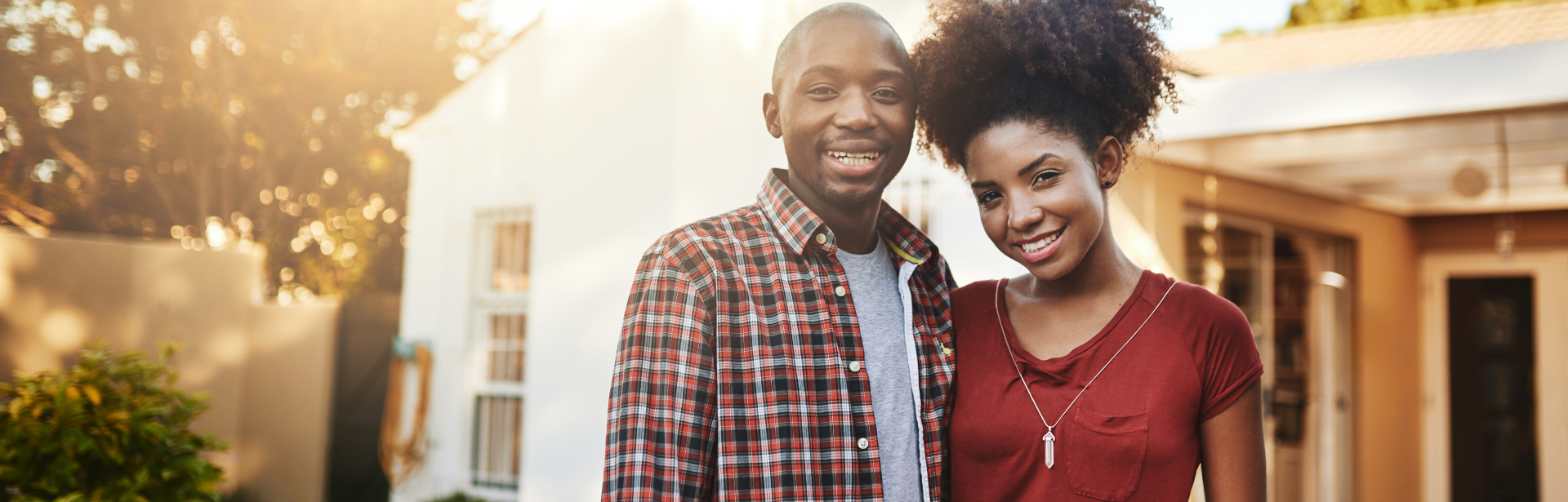 young couple in front of home