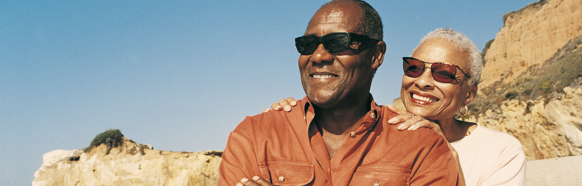 Two people standing in an open plain, smiling.