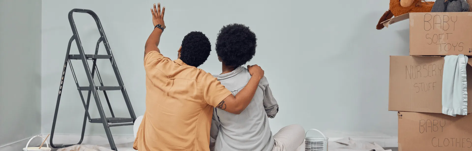 A couple sitting at the ground admiring the new home.