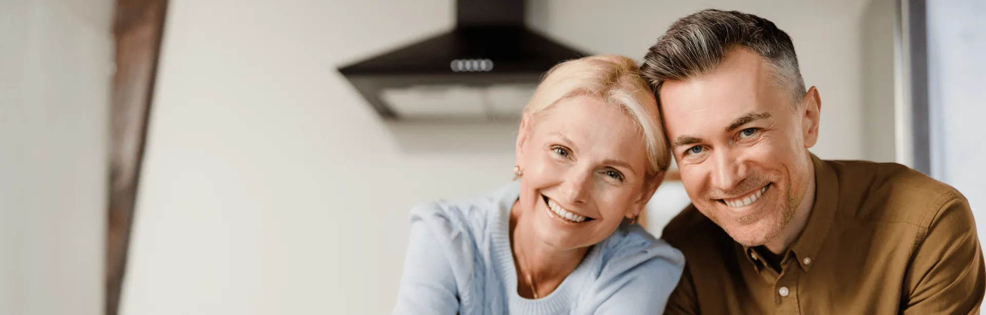A couple leans their heads against each other.