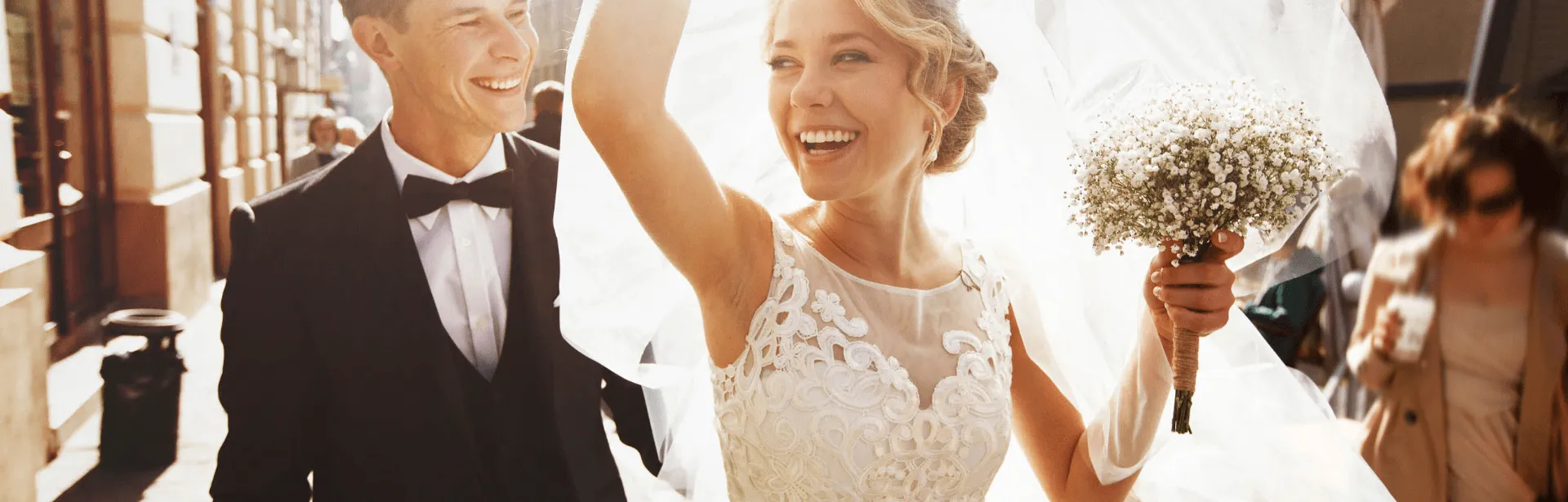 A newly wed couple standing and celebrating while smiling.