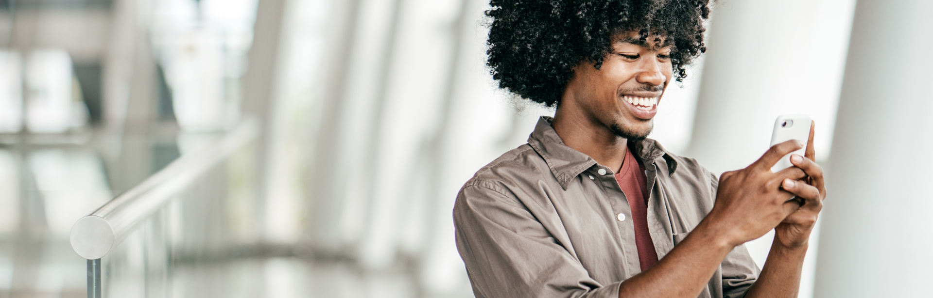 young man smiling holding mobile phone