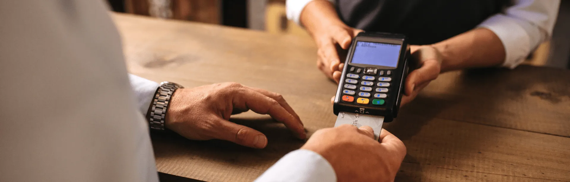 A person using their debit card at a debit card machine.