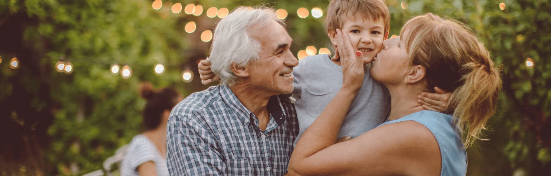 Two people holding a child and smiling.